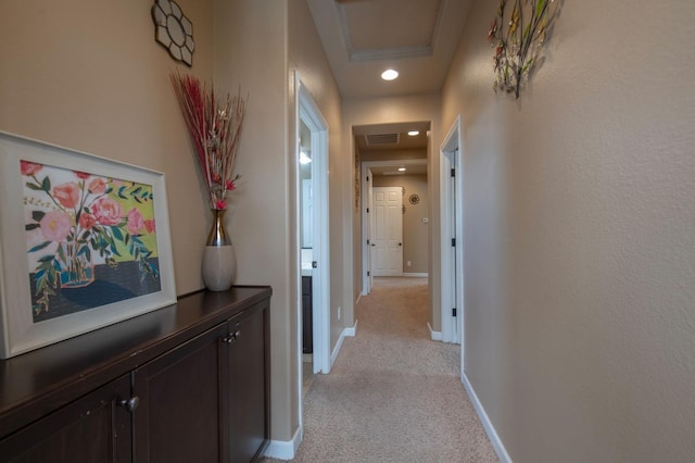 corridor featuring baseboards, recessed lighting, visible vents, and light colored carpet