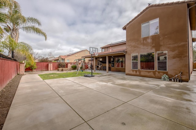 rear view of house featuring a tile roof, a patio area, a fenced backyard, and stucco siding