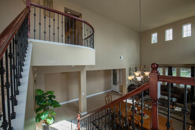 stairway featuring visible vents, a towering ceiling, a chandelier, baseboards, and tile patterned floors