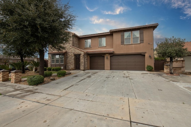 view of front of home with a tile roof, stucco siding, a garage, stone siding, and driveway