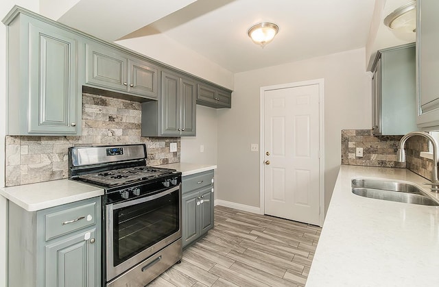 kitchen featuring light wood-style floors, light countertops, a sink, and gas stove