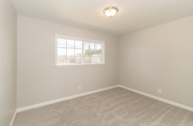 empty room featuring carpet floors and baseboards