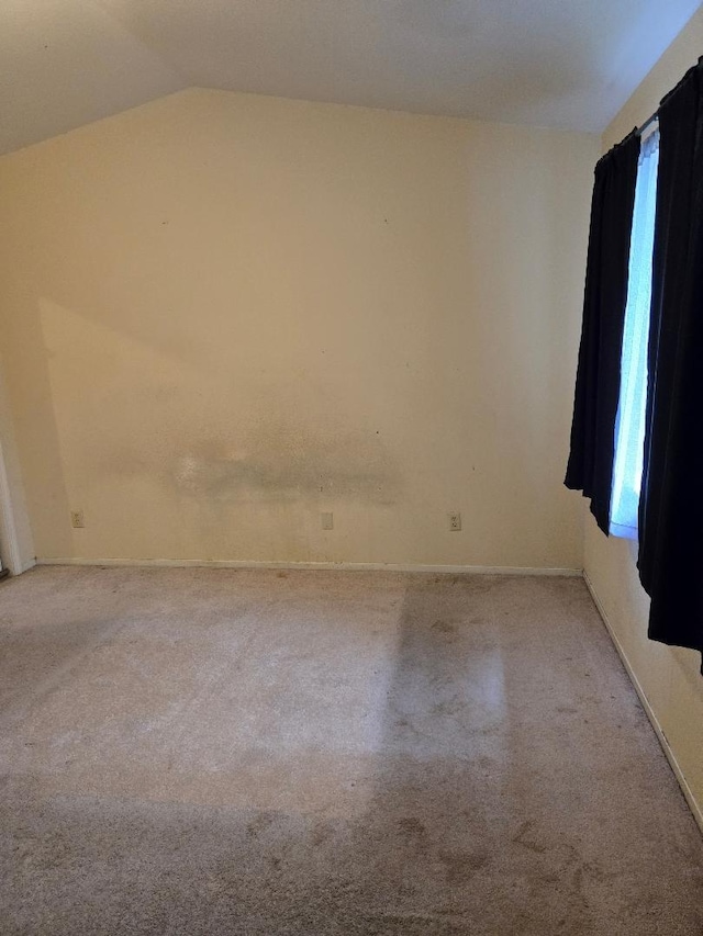 unfurnished room featuring carpet flooring and lofted ceiling