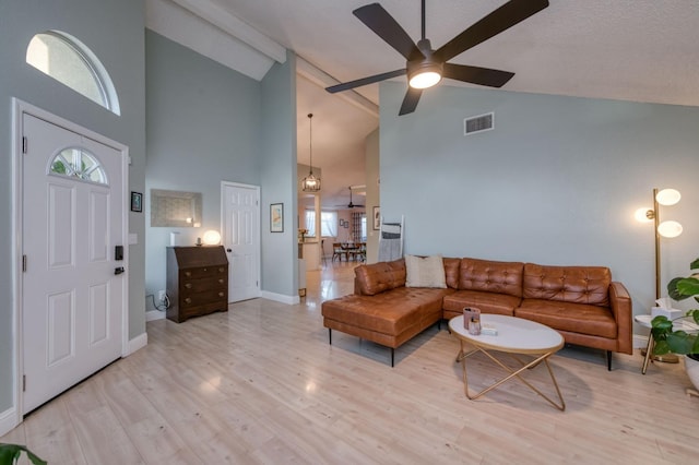 living area with ceiling fan, wood finished floors, visible vents, and baseboards