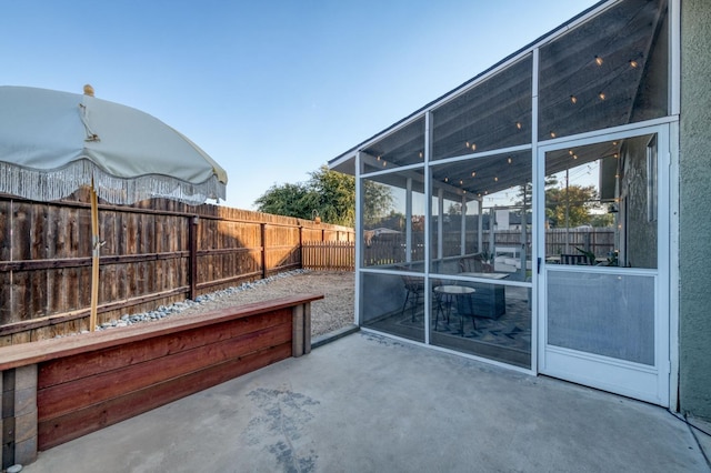 view of patio featuring a sunroom and fence