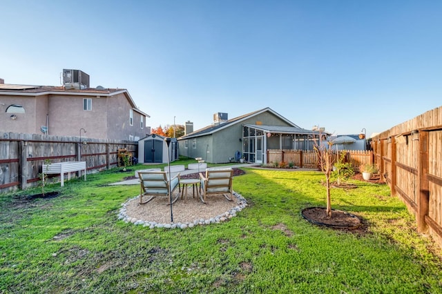 rear view of house featuring an outbuilding, a fenced backyard, a lawn, and a shed