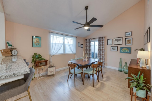 dining room with a ceiling fan, lofted ceiling, baseboards, and light wood finished floors