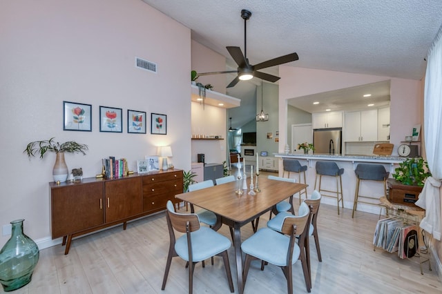 dining space featuring visible vents, ceiling fan, a textured ceiling, and light wood finished floors