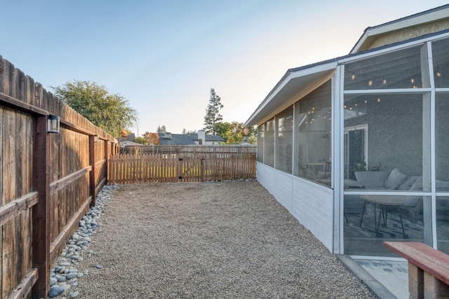 view of yard featuring a sunroom and a fenced backyard