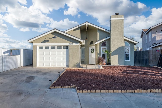 ranch-style home with a chimney, stucco siding, concrete driveway, an attached garage, and fence