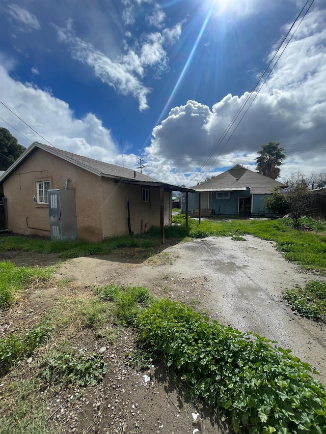 view of side of property with driveway and stucco siding