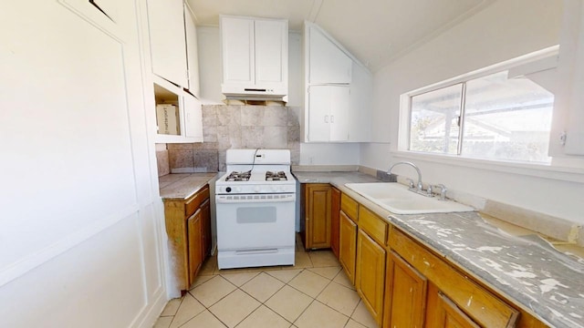 683 E Polk St, Coalinga, CA 93210 - kitchen featuring light tile patterned floors, a sink, brown cabinetry, and gas range gas stove