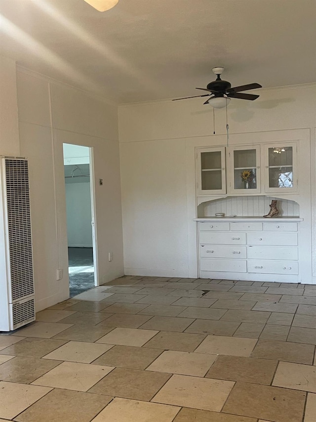 unfurnished room with ceiling fan and a heating unit