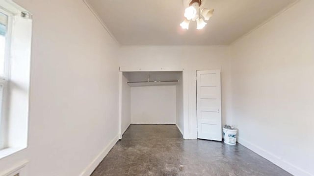 683 E Polk St, Coalinga, CA 93210 - unfurnished bedroom featuring crown molding, baseboards, an inviting chandelier, and concrete floors