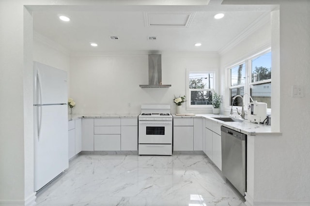 kitchen featuring white appliances, ornamental molding, white cabinets, and wall chimney range hood