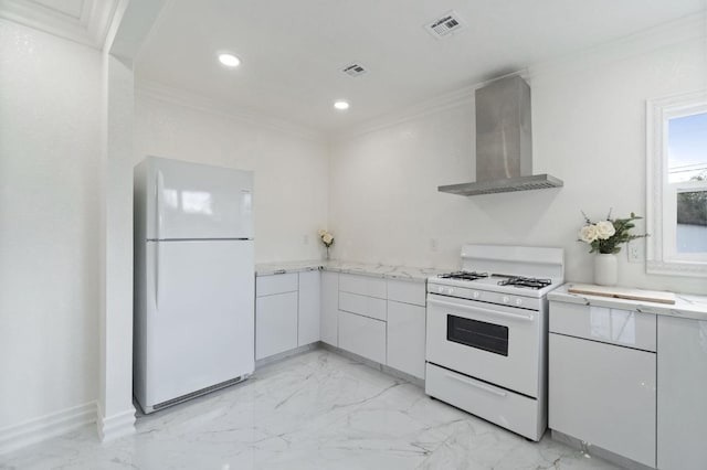 kitchen with marble finish floor, ornamental molding, white cabinets, wall chimney range hood, and white appliances