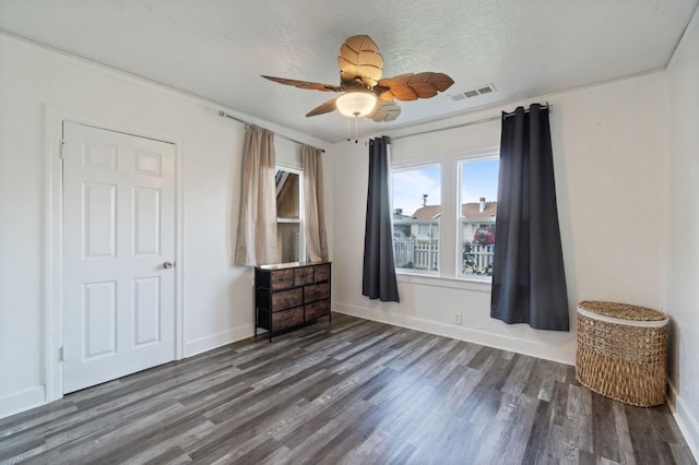 bedroom with baseboards, visible vents, wood finished floors, and ornamental molding