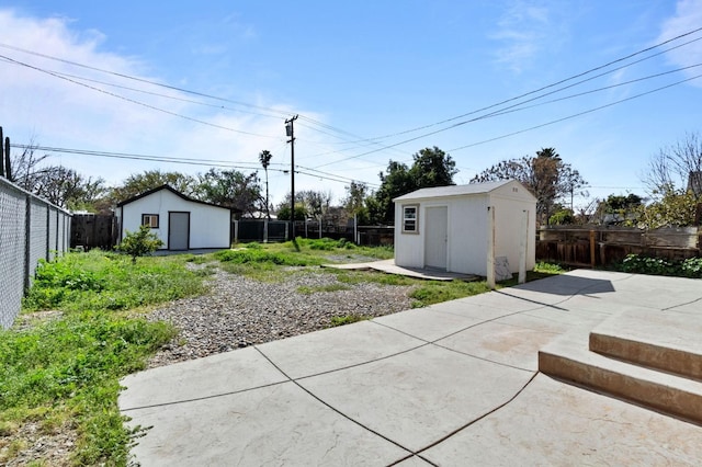 exterior space featuring a fenced backyard, a storage unit, and an outbuilding