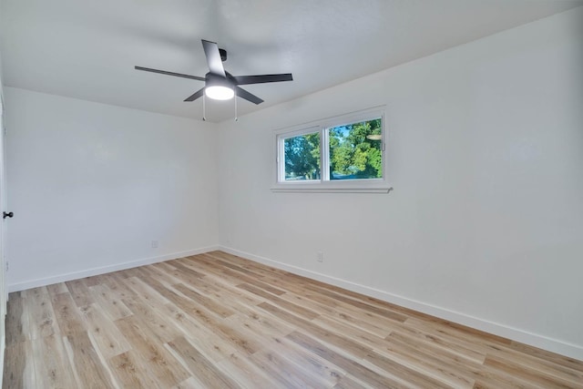 unfurnished room with light wood-type flooring, a ceiling fan, and baseboards