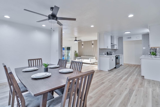 dining room with light wood-style floors, baseboards, visible vents, and recessed lighting