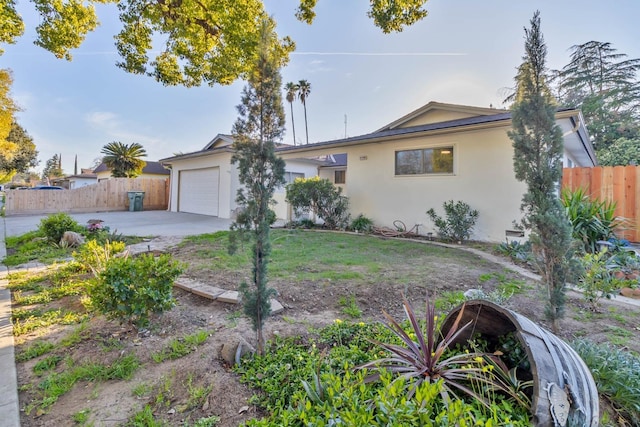 ranch-style house with a garage, driveway, fence, and stucco siding