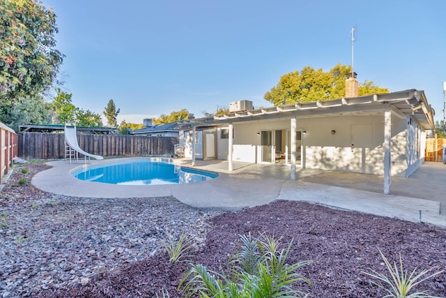 view of pool featuring central AC unit, a water slide, a fenced backyard, a fenced in pool, and a patio area