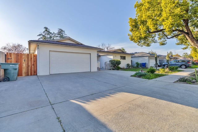 ranch-style home with a garage, fence, and stucco siding