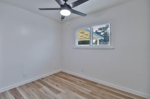 empty room featuring a ceiling fan, light wood finished floors, and baseboards