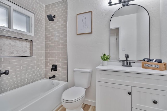 bathroom featuring shower / bath combination, baseboards, toilet, wood finished floors, and vanity