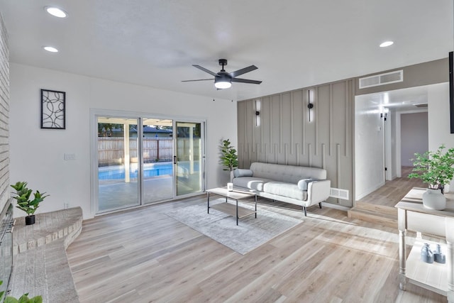 living area with light wood-style floors, ceiling fan, visible vents, and recessed lighting