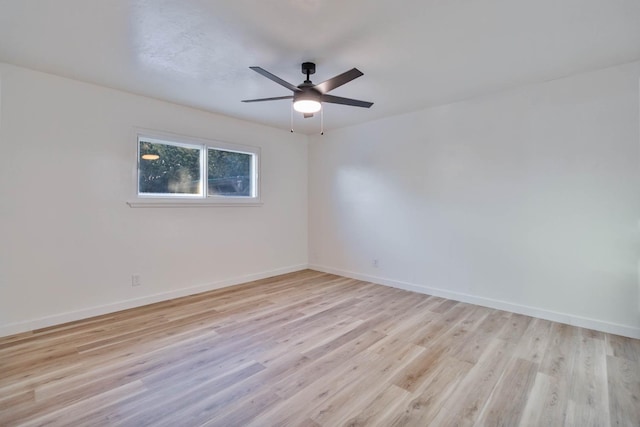 unfurnished room featuring baseboards and light wood-style floors