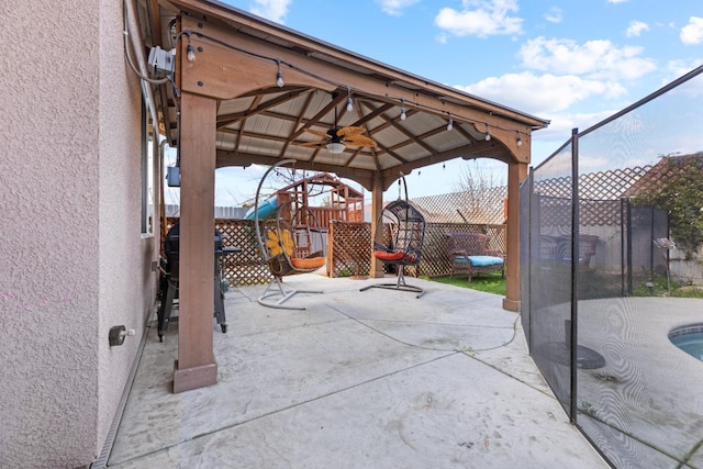 view of patio / terrace featuring a grill, a playground, fence, and a ceiling fan