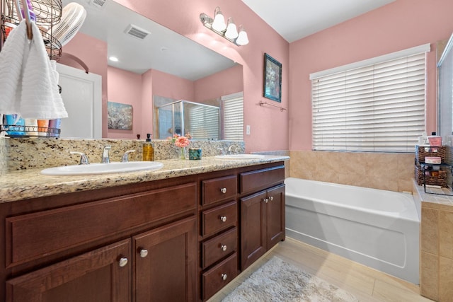 bathroom featuring a sink, visible vents, a bath, double vanity, and a stall shower