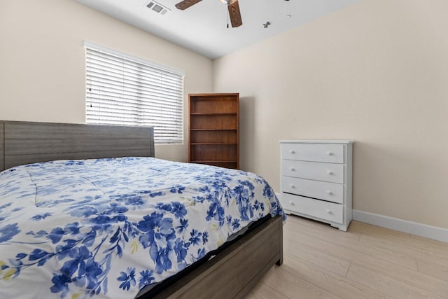 bedroom with light wood-style floors, baseboards, visible vents, and ceiling fan