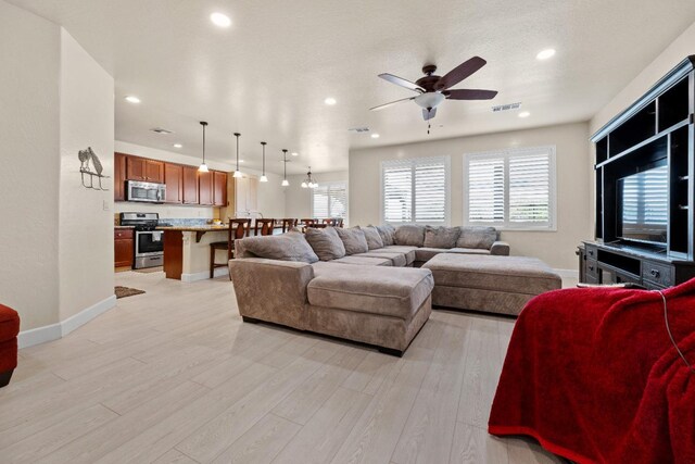 living room with light wood-style floors, recessed lighting, visible vents, and baseboards