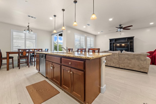 kitchen featuring dishwasher, light wood-style flooring, a sink, and visible vents