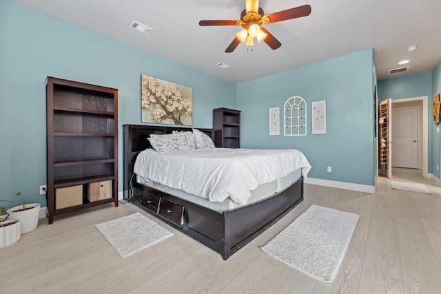 bedroom featuring baseboards, visible vents, and wood finished floors