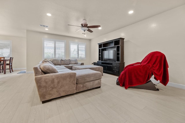 living area featuring recessed lighting, light wood-type flooring, a ceiling fan, and baseboards