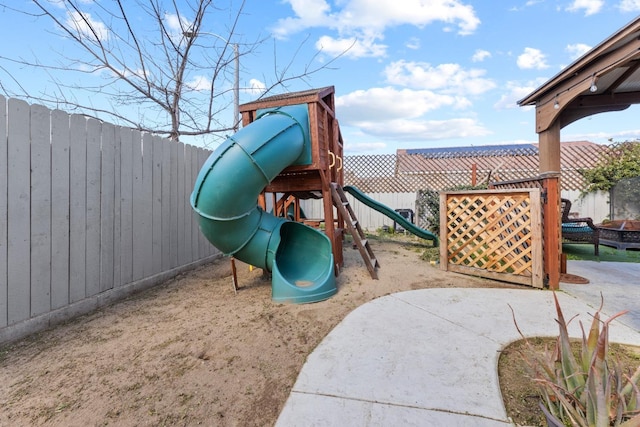 view of playground with a fenced backyard and a patio