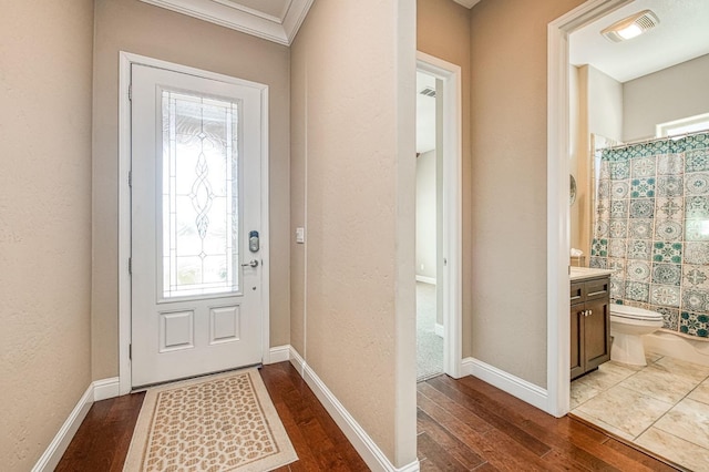 entrance foyer with baseboards, visible vents, and dark wood finished floors