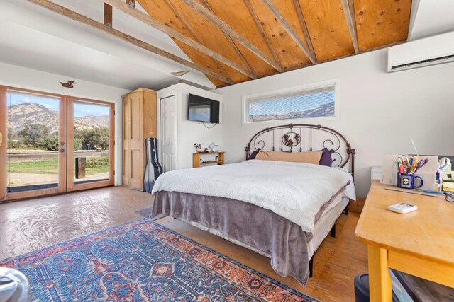 bedroom featuring french doors, vaulted ceiling with beams, an AC wall unit, a mountain view, and access to outside