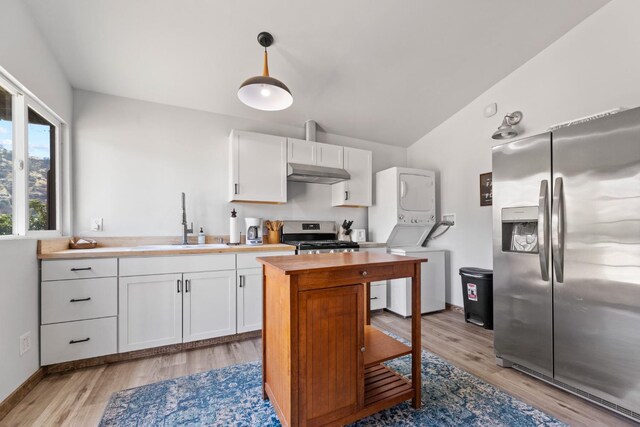 kitchen with white cabinets, butcher block countertops, stainless steel appliances, under cabinet range hood, and a sink