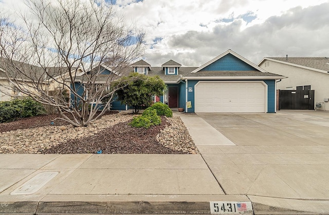 view of front of property featuring a garage, concrete driveway, and fence