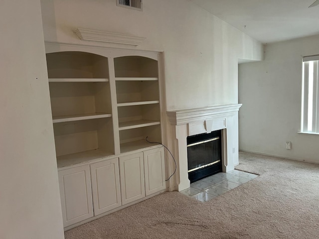 unfurnished living room featuring a fireplace with flush hearth, visible vents, and light colored carpet