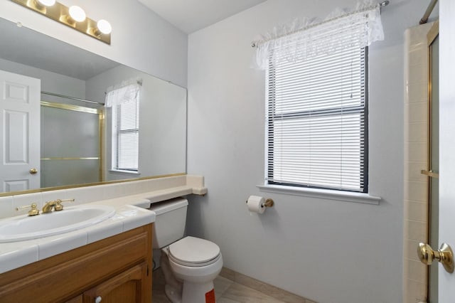 bathroom featuring a shower with door, vanity, and toilet