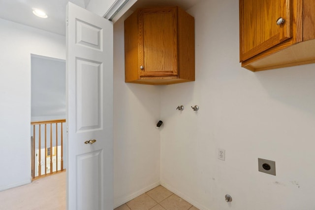 laundry area featuring baseboards, light tile patterned floors, cabinet space, and hookup for an electric dryer