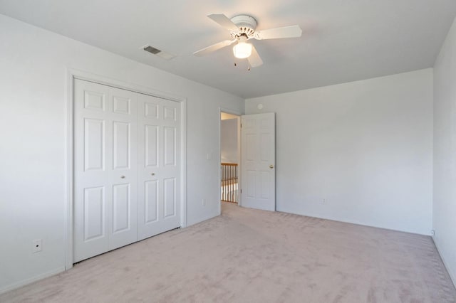 unfurnished bedroom with a ceiling fan, carpet, visible vents, and a closet