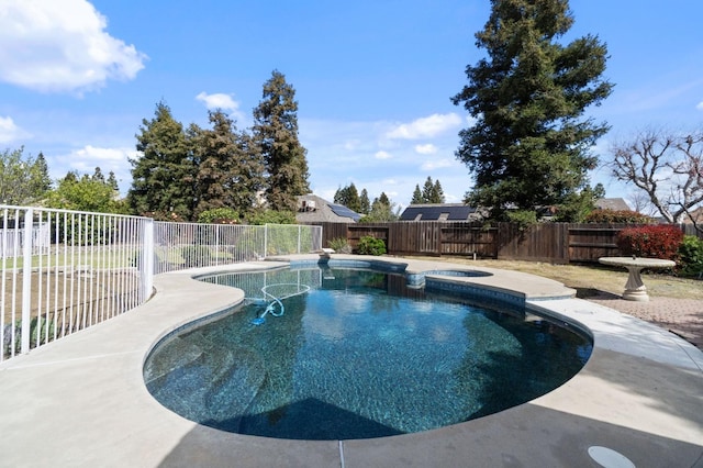 view of pool with a fenced backyard and a pool with connected hot tub