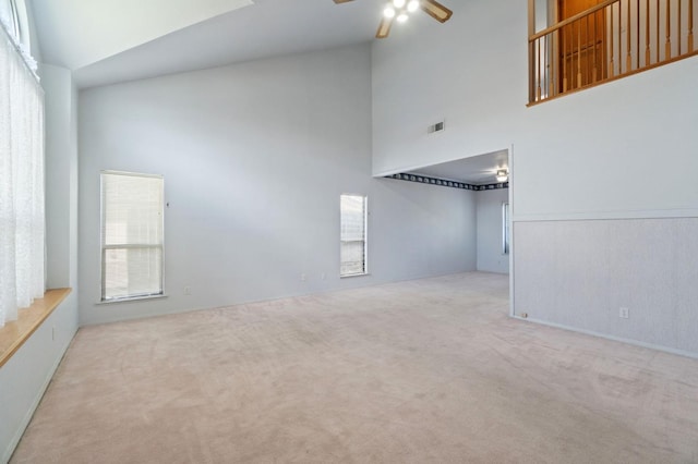 unfurnished room featuring a ceiling fan, carpet, visible vents, and high vaulted ceiling