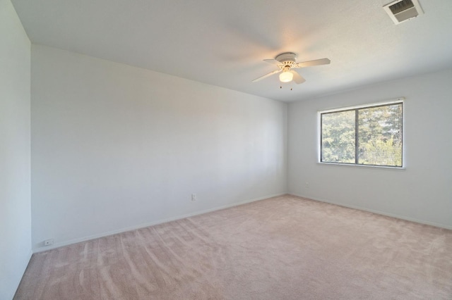 spare room with light carpet, ceiling fan, and visible vents